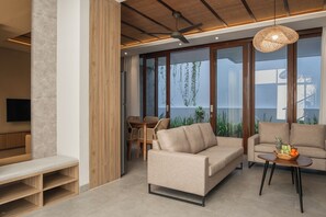 Ein modernes Wohnzimmer mit einer Couch, einem Couchtisch, einer Bank und einem Essbereich mit Tisch und Stühlen.