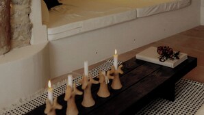 A stone fireplace with a bench, candles, and a book on a table. - Cozy and refined retreat in the heart of Fanjeaux (Fanjeaux)