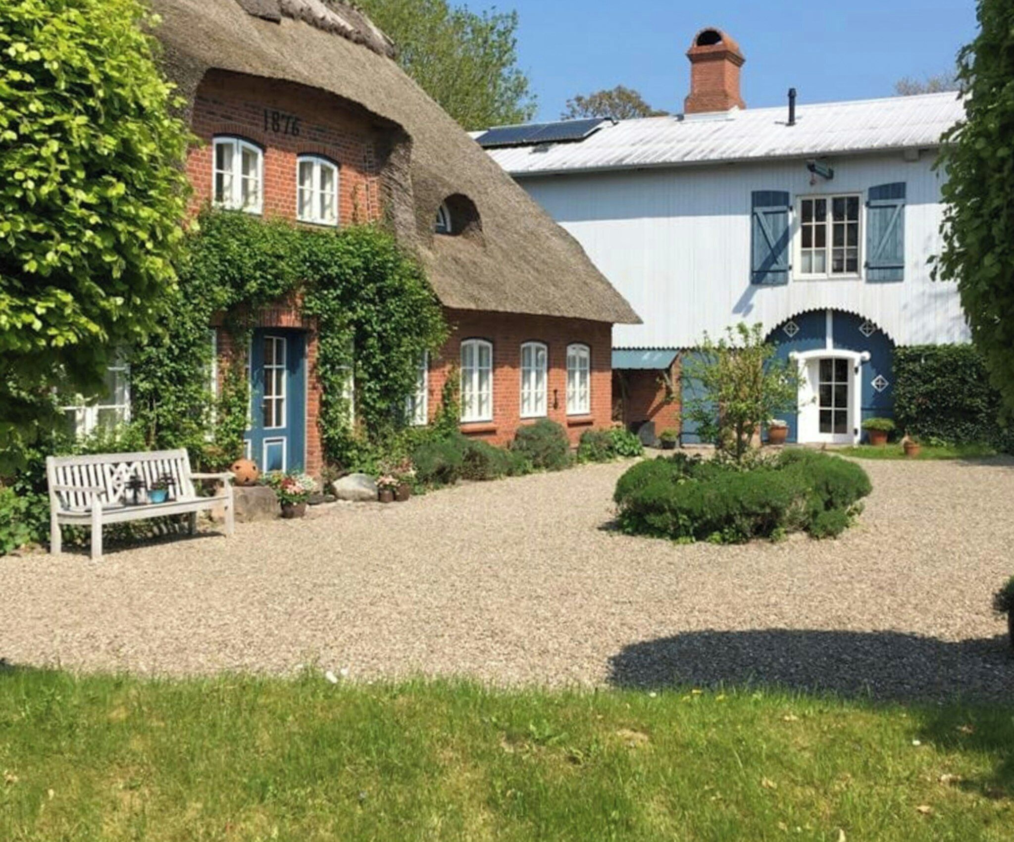 A traditional building with a thatched roof, a brick facade, and a white exterior.
