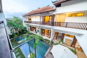 Una casa de varios pisos con piscina, balcones y jardín.