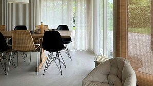 Un comedor moderno con techo de madera, ventanas amplias y una distribución de asientos acogedora.