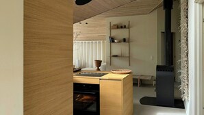 Una cocina moderna con horno integrado, una isla central y una estufa negra.