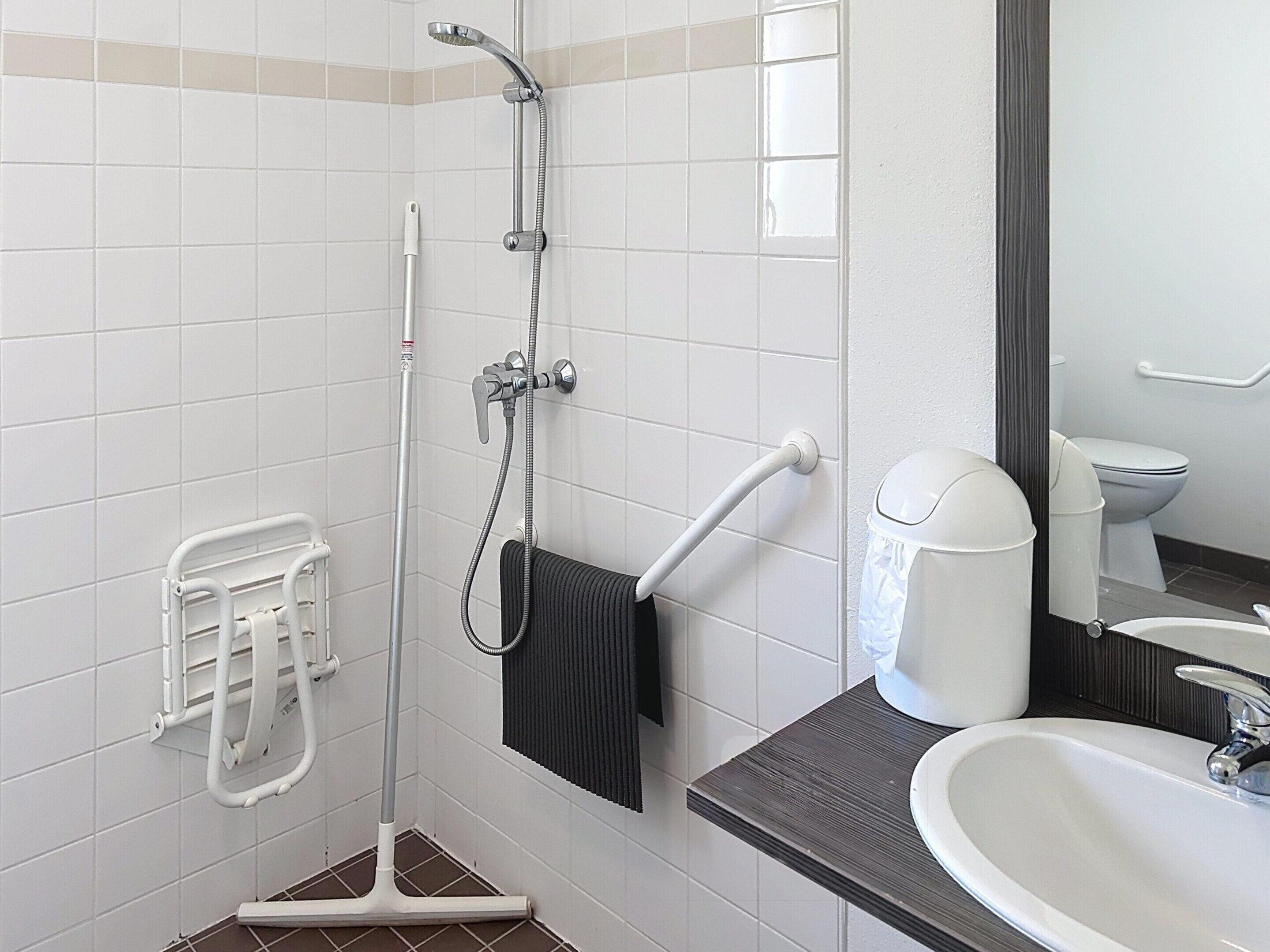Une salle de bain équipée d’une douche, de toilettes, d’un lavabo et d’un porte-serviettes.