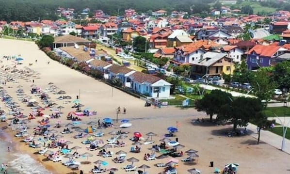 A beach with rows of colorful houses and a sandy beach area.