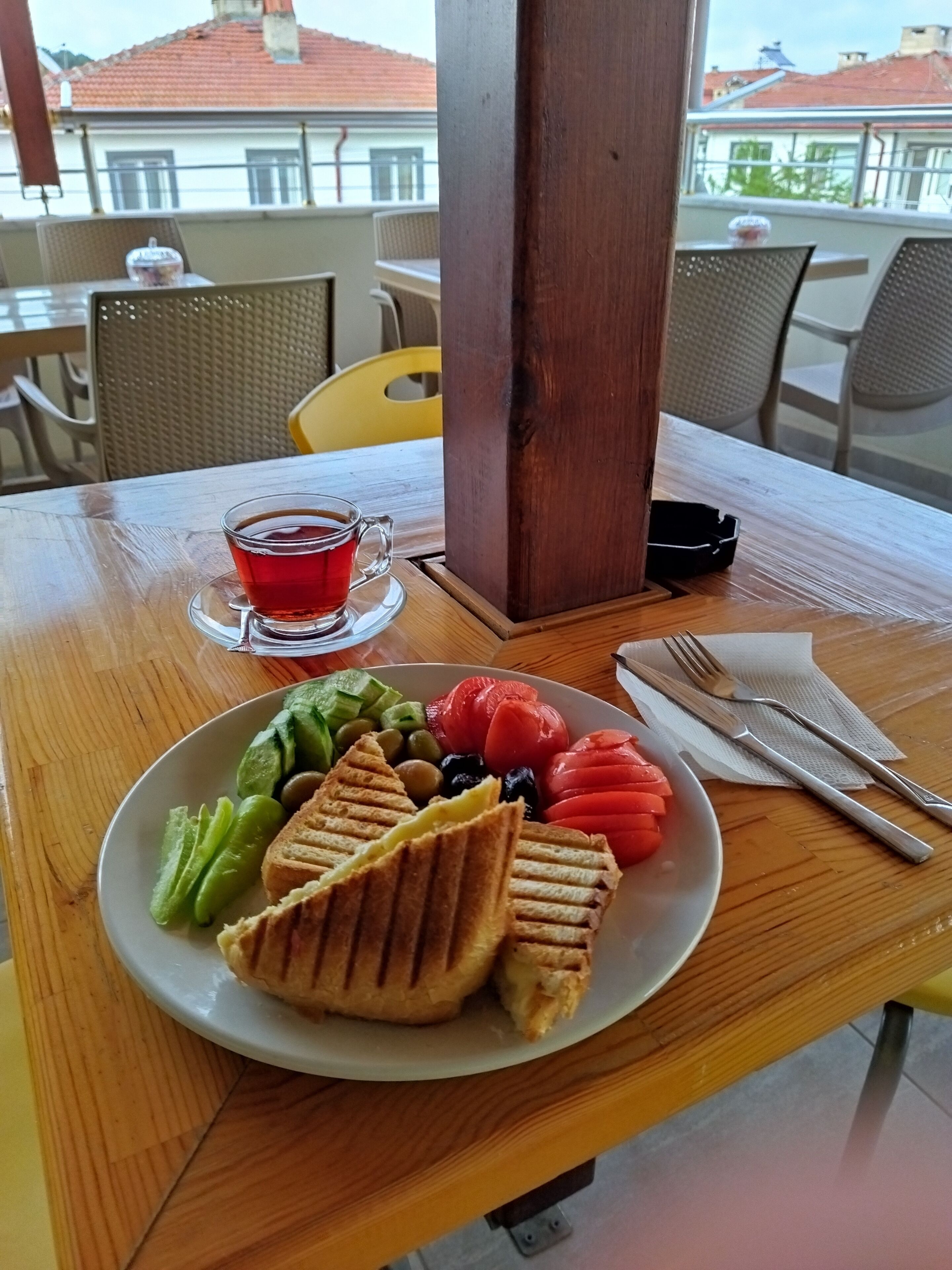 Puisesta pöydästä löytyy lautanen ruokaa, lasi punaista juomaa ja ruokailuvälineet.