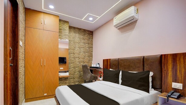 A bedroom with a bed, wardrobe, TV, and air conditioning unit. - Townhouse Oak Panki Panchmukhi Hanuman (Kanpur)