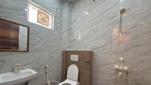A bathroom with a toilet, sink, and shower. - Maa Durga Dham (Vrindavan)