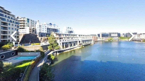 Un hôtel situé au bord de l’eau, doté d’une piscine, d’une architecture moderne et offrant une vue sur le plan d’eau.