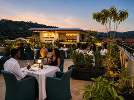 A Planet Hotel Restaurant with outdoor seating, a bar, and a view of the surrounding landscape.