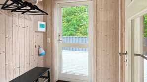 Un intérieur en bois comprenant une porte, un luminaire et un panneau de commande fixé au mur.