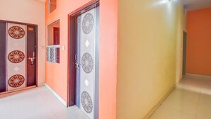 A hallway with two doors, one with a number '201' and another with a decorative design. - Hotel Radhe Radhe Near Jaipur Airport  (Jaipur)