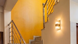 A staircase with marble steps, metal railings, and a wall-mounted light fixture. - Hotel Radhe Radhe Near Jaipur Airport  (Jaipur)