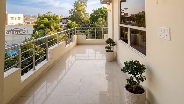 A balcony with a view of the city, a potted plant, and an air conditioning unit. - Hotel Radhe Radhe Near Jaipur Airport  (Jaipur)