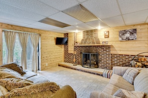 Una sala de estar acogedora con chimenea, televisor de pantalla plana y un sofá cómodo.