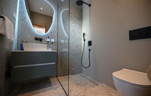 A modern bathroom with a large mirror, a white sink, a shower, and a toilet. - Awesome home in Smokovic with sauna (Smokovic)