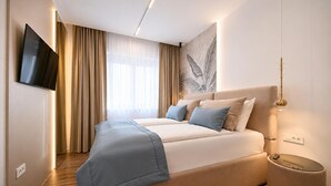 Une chambre d’hôtel moderne dotée d’un grand lit, d’un téléviseur à écran plat et d’une œuvre d’art accrochée au mur.
