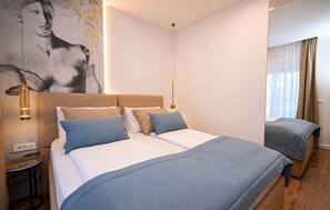 A modern hotel room with a large bed, bedside tables, a wall-mounted lamp, and a window with curtains. - Awesome home in Smokovic with sauna (Smokovic)