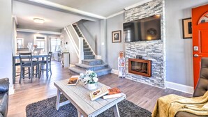 Ein geräumiges Wohnzimmer mit Kamin, Essbereich und einer Treppe zu einer oberen Etage.
