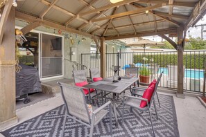 A covered patio with a table and chairs, a grill, and a view of a swimming pool. - 1 Mile to Downtown Disneyland R District (Anaheim)