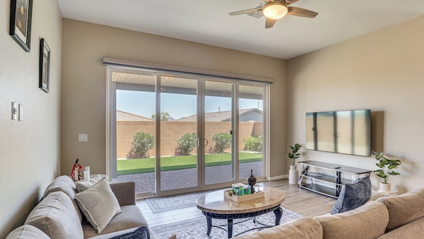 A living room with a sofa, coffee table, TV, and sliding glass doors leading to a patio. - 9 Mi to Las Vegas Strip! Spacious Single-Story Gem (Las Vegas)