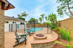 A backyard with a pool, a fire pit, and outdoor furniture. - Sleek Family Home w/ Backyard Oasis in San Diego! (San Diego)