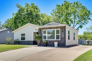 A single-story house with a front porch, a garage, and a well-maintained lawn. - 2 Mi to Stadiums & UT Arlington! Stylish Home (Arlington)