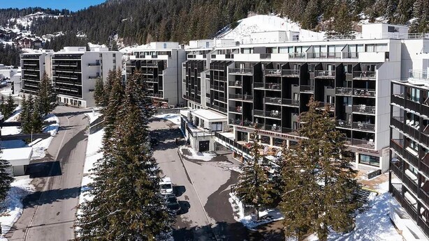 A modern hotel with multiple floors, balconies, and a parking area. - Résidence Pierre & Vacances Mountain view (Flaine)