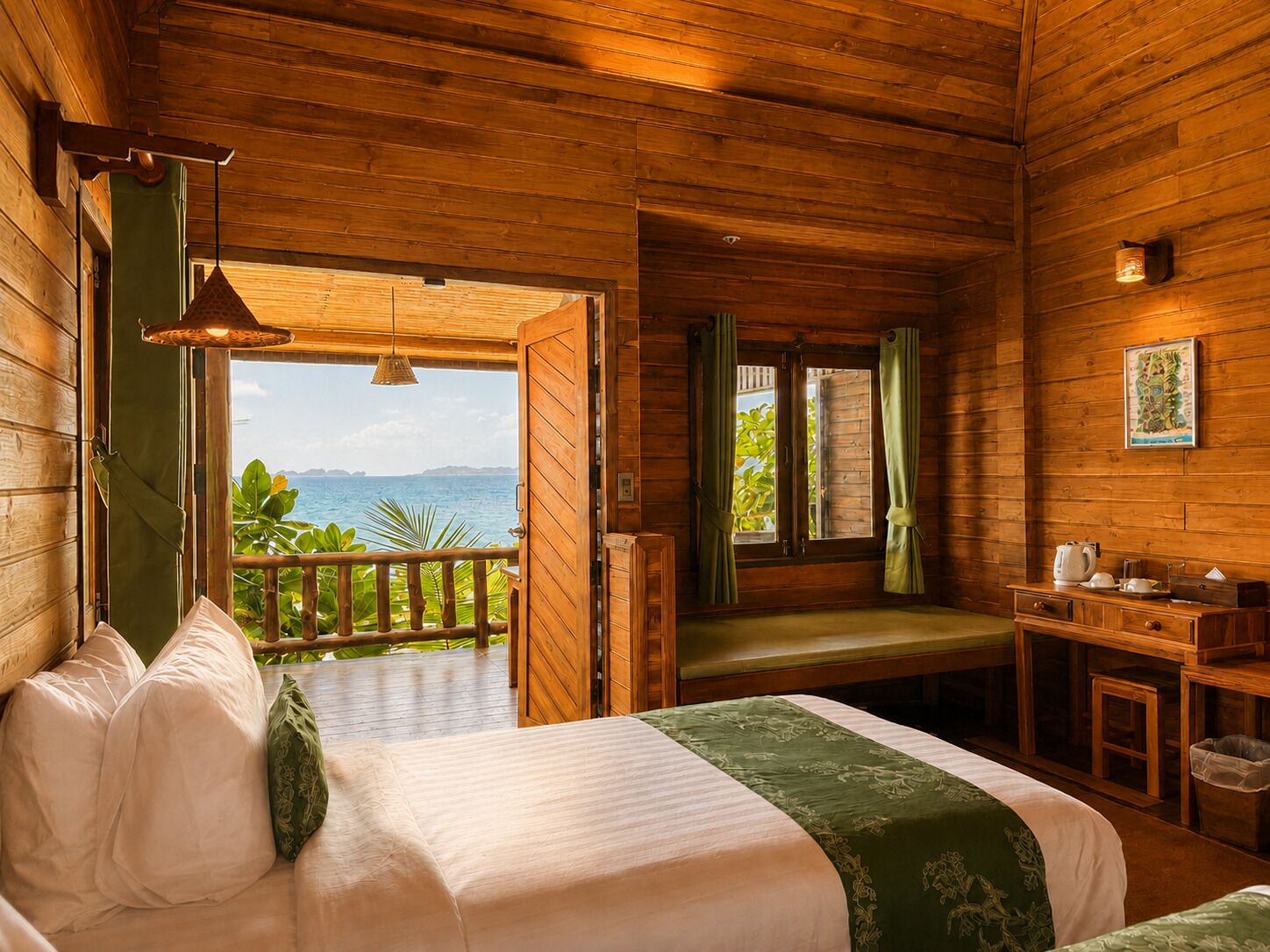 A wooden cabin room with a bed, a small table, and a view of the ocean.