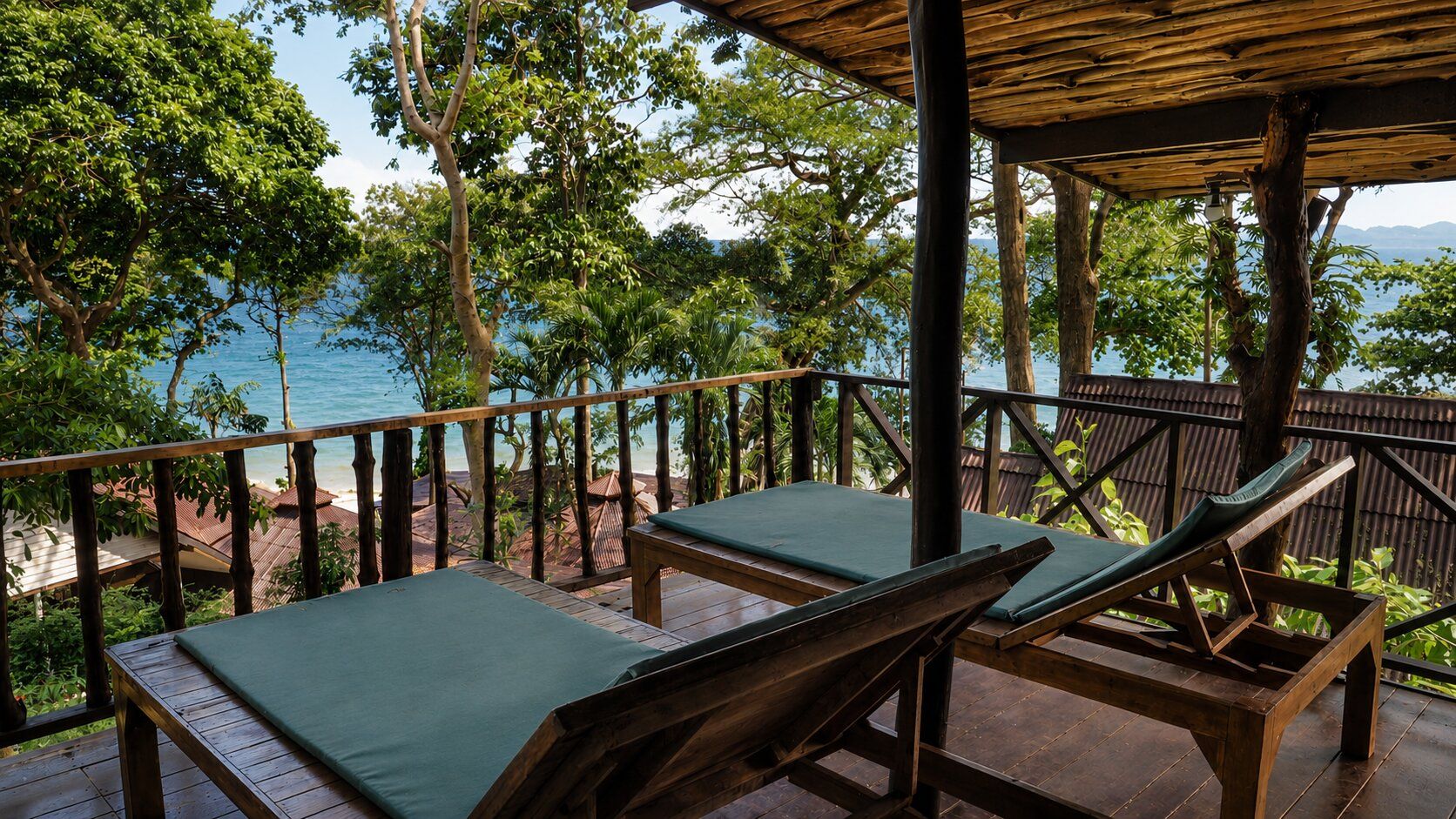 Una terraza de madera con dos sillones de descanso, una pérgola de madera y vista al mar.