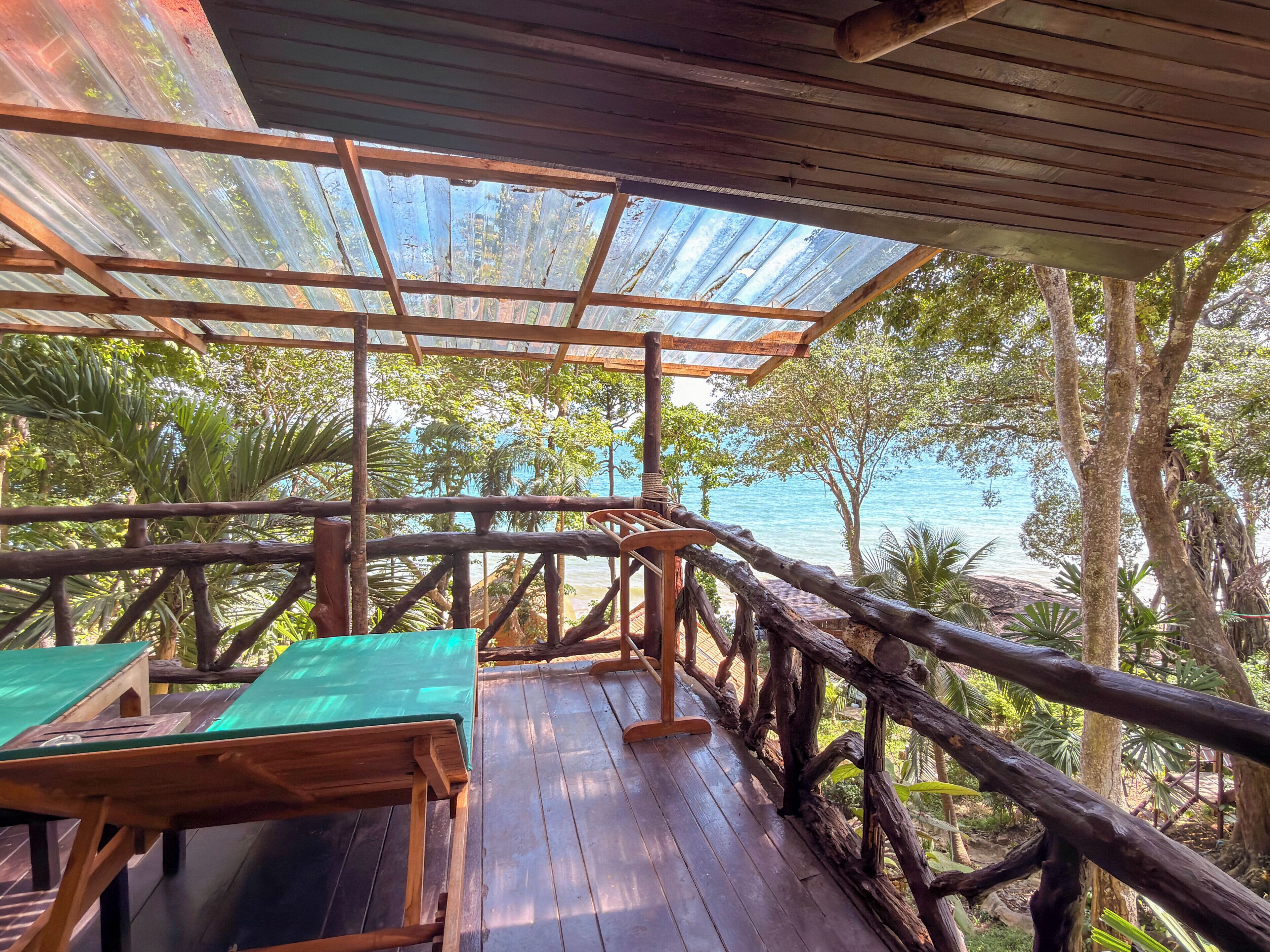 A wooden deck with a view of the ocean, surrounded by trees.