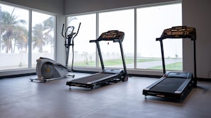 A gym with cardio equipment including a stationary bike, two treadmills, and a rowing machine.