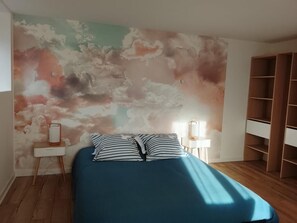 Ein Schlafzimmer mit einem Bett, einem Nachttisch, einer Wandlampe und einem Holzschrank.