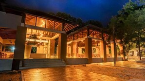 A modern house with a wooden deck, large windows, and a covered outdoor area. - Paradise Bay Resort - Arugambay  (Arugambay)