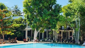 A swimming pool surrounded by trees and outdoor furniture. - Paradise Bay Resort - Arugambay  (Arugambay)