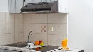 A kitchen with a sink, countertop, and a glass of orange juice.
