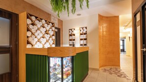 A reception area with a wooden counter, a glass display case, and a green panel. - Termy Szaflary (Szaflary)