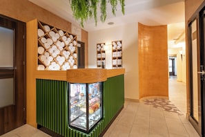 A reception area with a wooden counter, a glass display case, and a green panel. - Termy Szaflary (Szaflary)