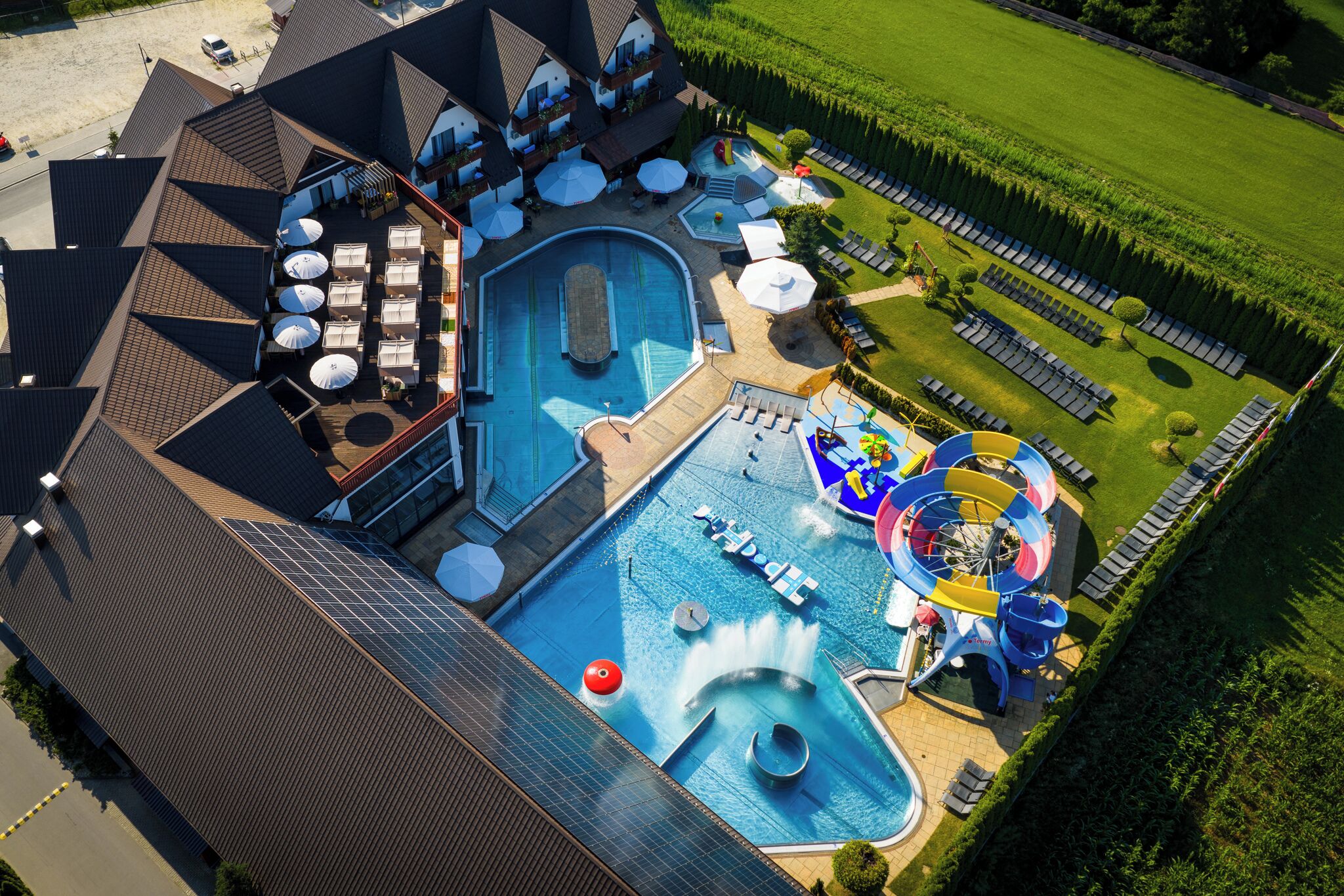 A rooftop pool with a water slide and lounge area.
