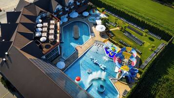 A rooftop pool with a water slide and lounge area.