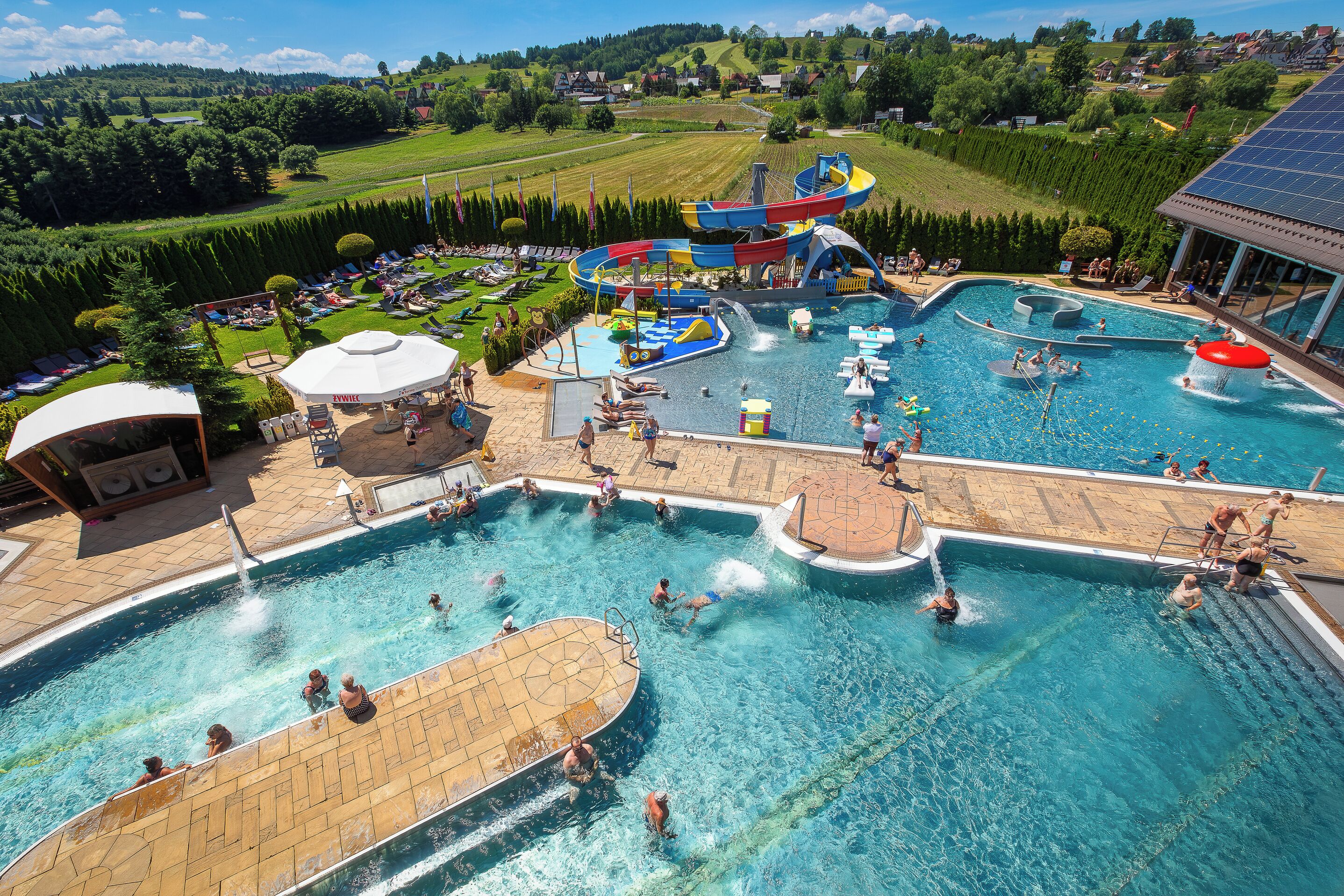 Un resort con varias piscinas, parque acuático y vistas panorámicas del paisaje circundante.