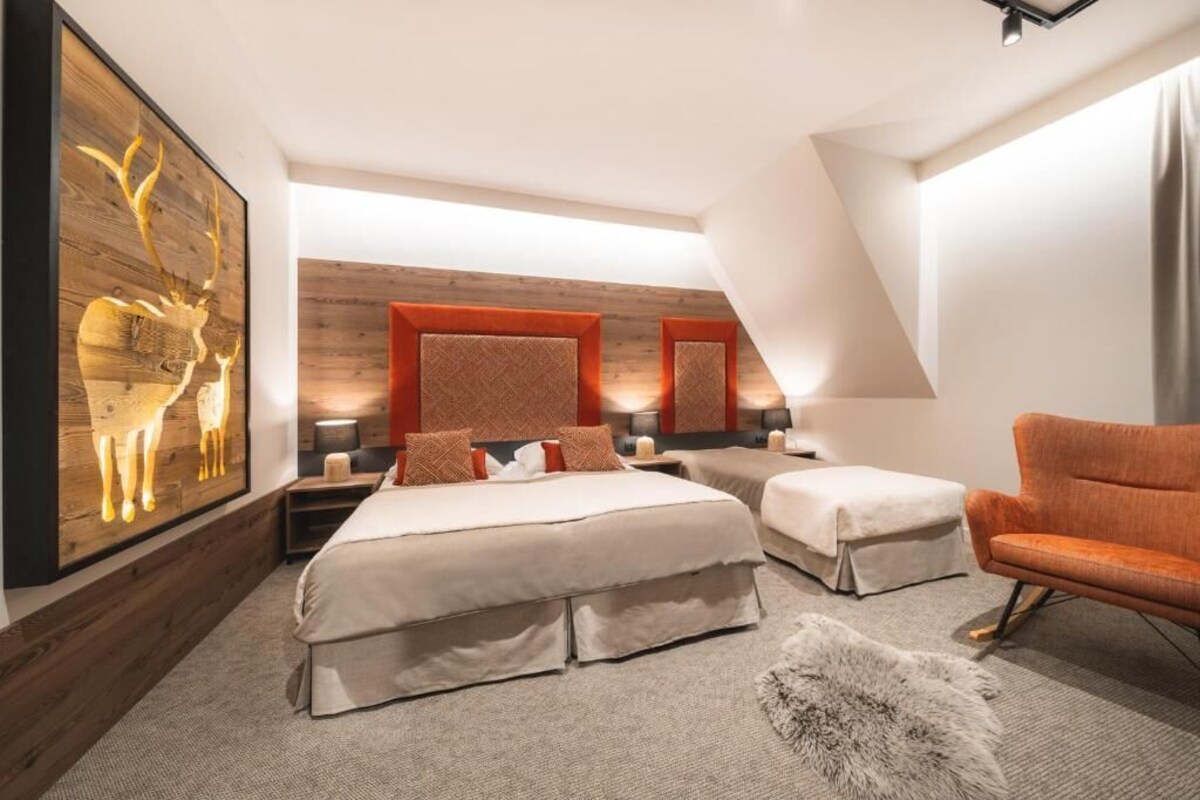 Un dormitorio con una cama grande, dos mesitas de noche, una silla y una obra de arte en la pared.