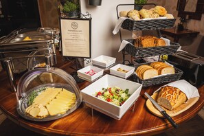A buffet with various food items including bread, cheese, and a salad.
