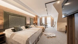 Een moderne hotelkamer met twee bedden, een groot hoofdeinde, een flatscreen televisie en een zacht tapijt.