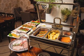 A buffet setup with various food items including sliced meats, vegetables, and prepared dishes. - Termy Szaflary (Szaflary)