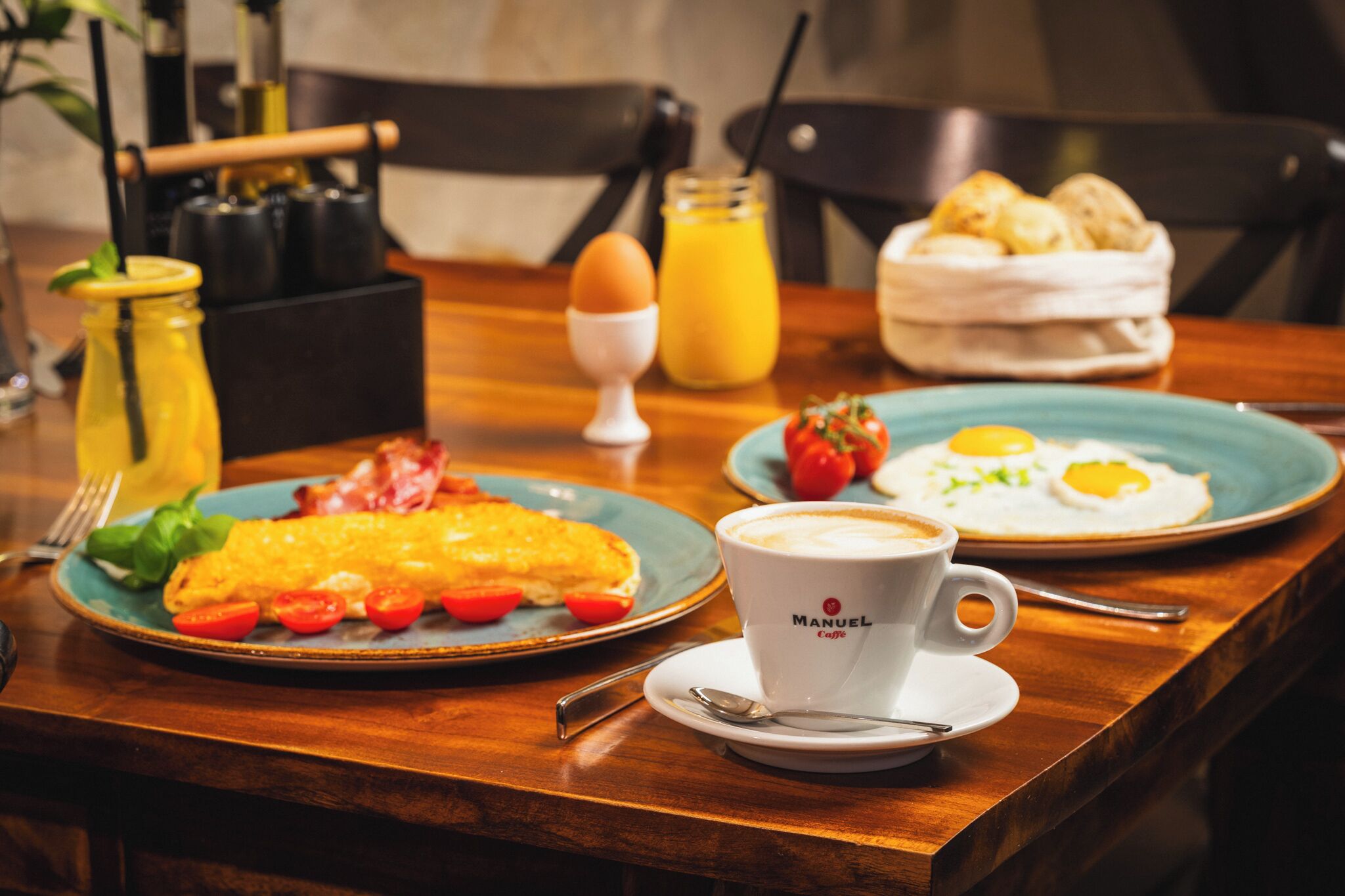 A breakfast table with plates of eggs, toast, and a coffee cup.