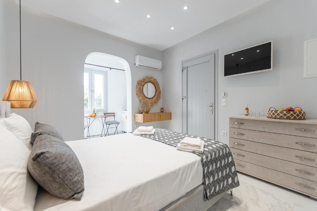 Ein Schlafzimmer mit Bett, Kommode, Fernseher und Spiegel.