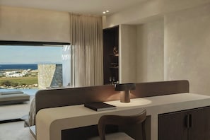 A modern bedroom with a large window, a bedside table, a chair, and a built-in shelf. - Orosea, Paros, Autograph Collection (PAROS)