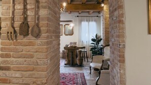 A rustic interior with exposed brick walls, wooden beams, and a stone floor.