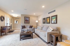 A living room with two sofas, a coffee table, a lamp, and wall art.