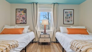 A double room with two beds, a nightstand, a lamp, and a window with curtains. - Vinyl & Velvet w/ Parking near Vandy/DTWN (Nashville)